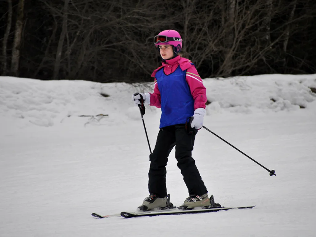 Skifahrerin in pinker Jacke auf der Piste.